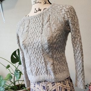Grey cable knit sweater with waffle knit sleeves and back.